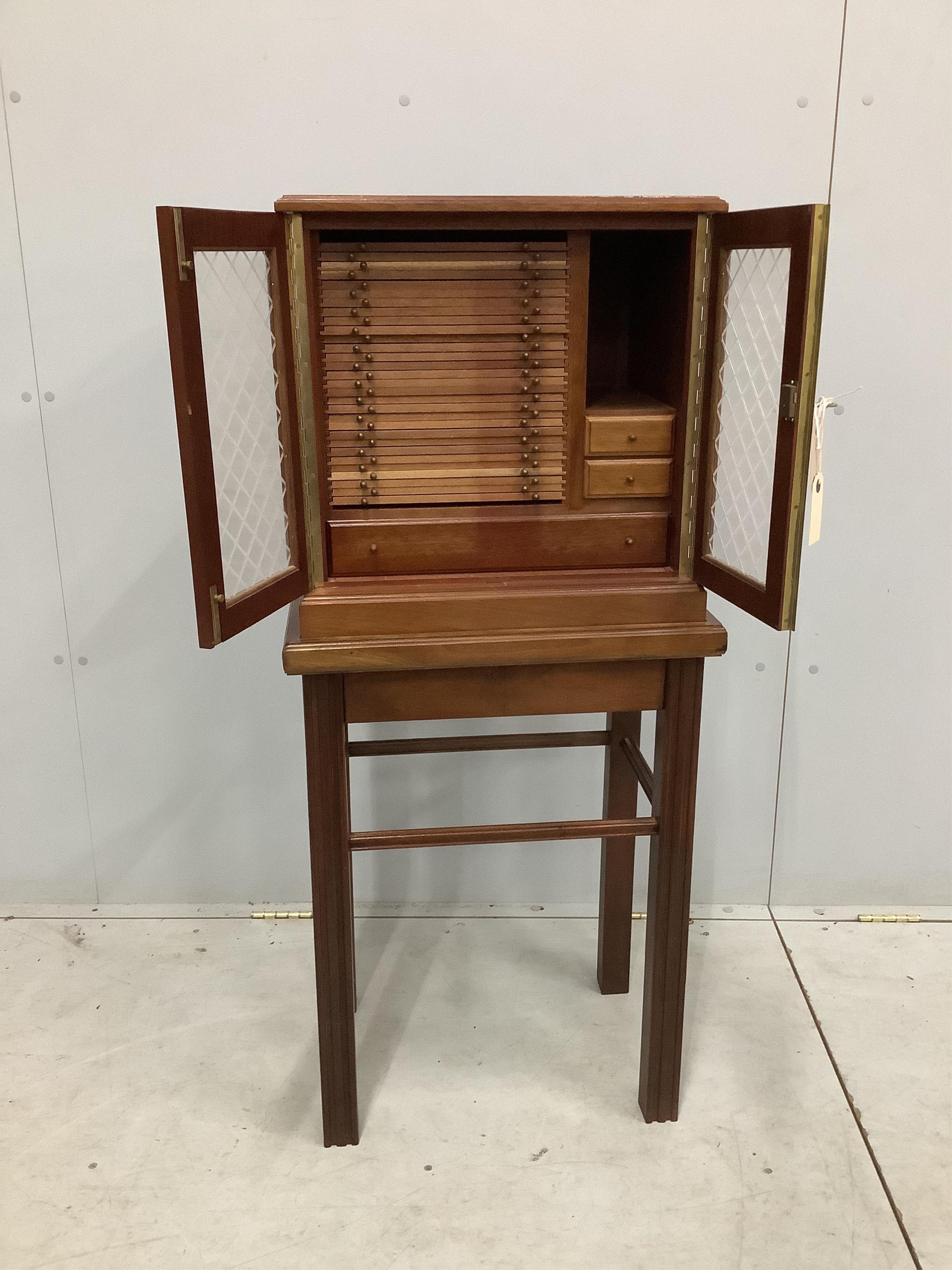 A modern mahogany coin collector's cabinet on stand